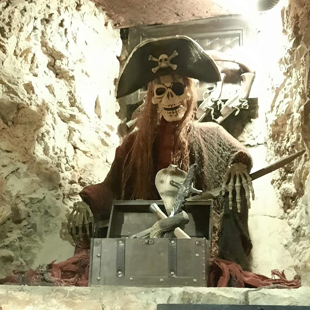 Pirate skeleton holding a sword and treasure chest.